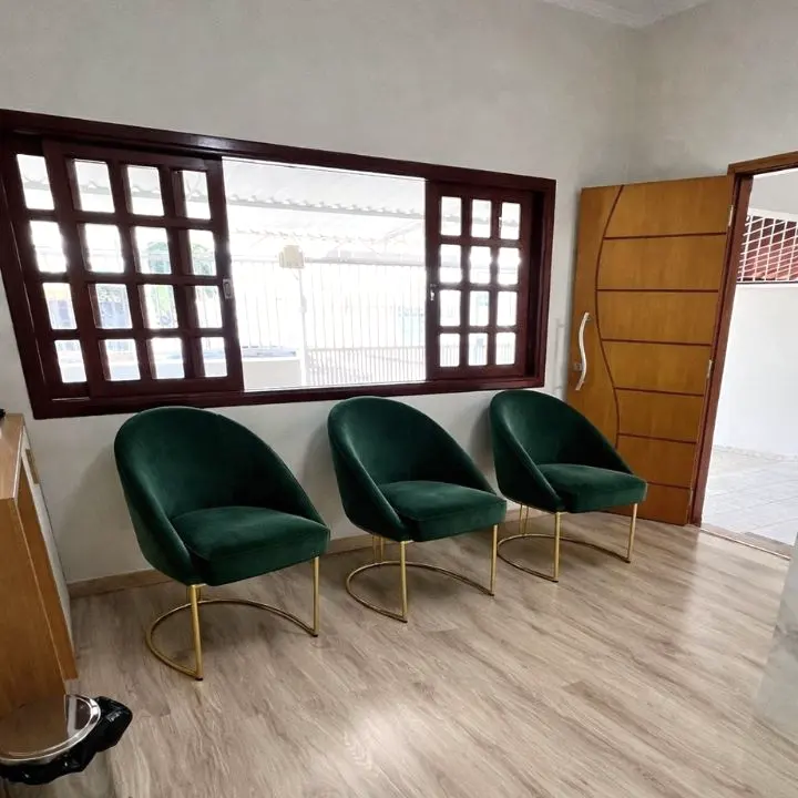 Sala de espera com poltronas verdes e janela
