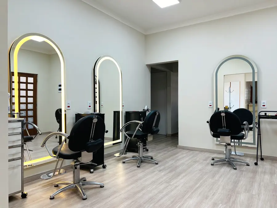 Área de cabelo com espelhos em arco e cadeiras